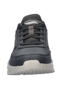 Zapatilla sintética negra con un collar acolchado, diseño de cordones, marca ArchFit y una suela de goma texturizada para un mejor agarre.