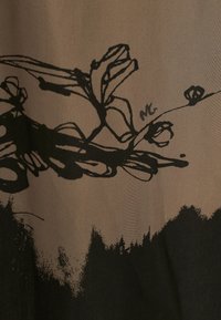 Tessuto marrone con un motivo floreale nero e linee astratte, che presenta diverse texture e un effetto sfumato nella parte inferiore.