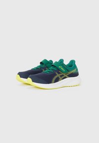 Baskets de course navy avec des accents verts, tige en mesh et semelle jaune vif. Équipées d'une sangle en Velcro et d'un détail de logo contrastant.