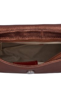 Ruda metalinė rankinė su tekstūruotu paviršiumi, su užtrauktuku ir kreminės spalvos interjeru, kuriame matoma maža raudona etiketė.