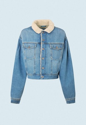 Femme portant une robe midi bleue à fleurs, un gilet en maille rouille, une veste en jean courte doublée en peau lainée, des collants noirs, des bottes lacées beige, tenant un sac à main marron.