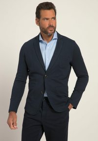 Blazer blu navy con due tasche frontali, chiusura a un bottone e una texture liscia, abbinato a una camicia button-up azzurra.
