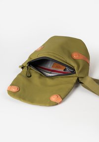 Borsa verde oliva con esterno in tessuto, accenti in pelle e apertura con zip. Presenta chiusure a scatto e un rivestimento interno a fantasia.
