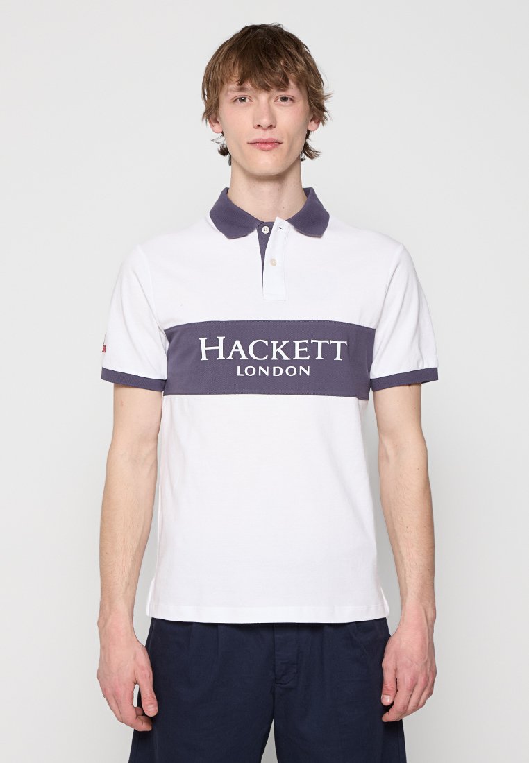 Polo blanc avec une rayure bleu marine. Il présente un col, deux boutons et le texte "HACKETT LONDON" imprimé en blanc. Manches courtes.