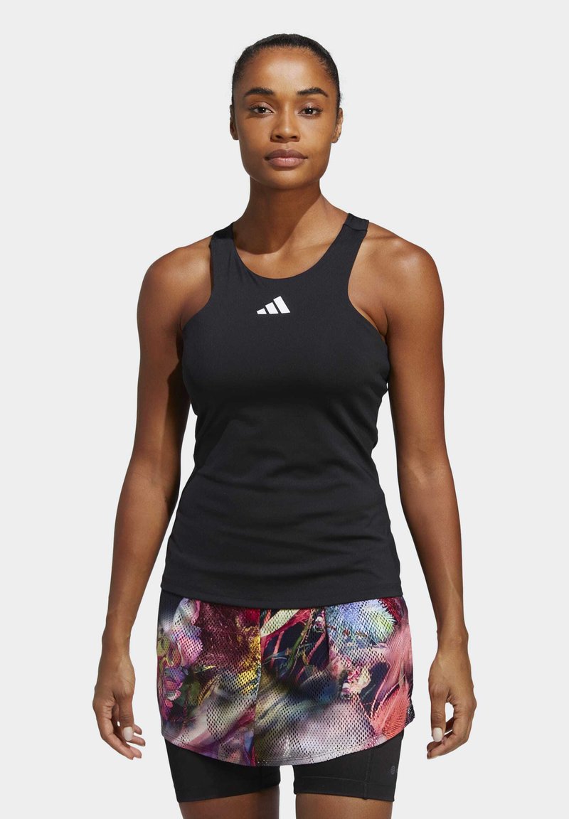 Zwarte sportieve tanktop met een ronde halslijn en wit logo, gecombineerd met kleurrijke shorts met bloemenpatroon. Heeft een aansluitende pasvorm.