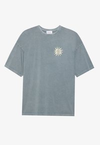 Light blue oversized t-shirt made of soft cotton with a round neckline and a yellow sun graphic on the left chest area.