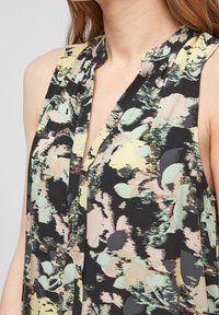 Bezramenný top z lehkého materiálu s černým pozadím a abstraktními pastelovými vzory v zelené, žluté a růžové barvě.