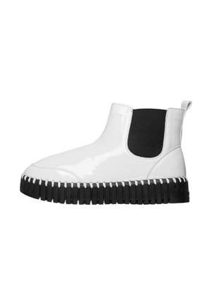 White patent leather ankle boots with black elastic side panels, thick black rubber sole, and white stitching details.