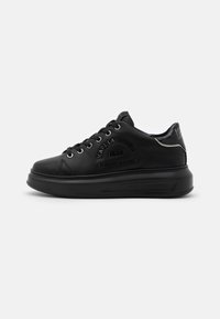 Black leather sneakers with a rounded toe, lace-up design, embossed logo on the side, and a thick platform sole. Textured accents included.