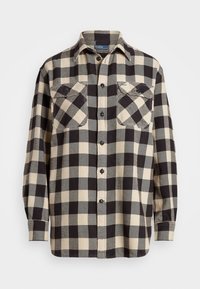 Black and cream checked flannel shirt with a button-up front, two chest pockets, and long sleeves. Soft fabric with a relaxed fit.