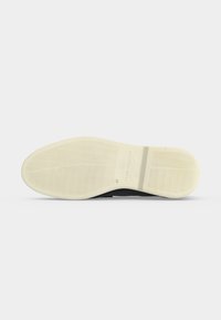 Σόλα μαύρου παπουτσιού με λευκή εξωτερική σόλα από καουτσούκ με κυματιστά σχέδια και μέγεθος 41 τυπωμένο κοντά στο κέντρο.