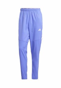 Světle fialové sportovní kalhoty s tapered designem, elastickým pasem a bílými logovými akcenty na boku a pase.