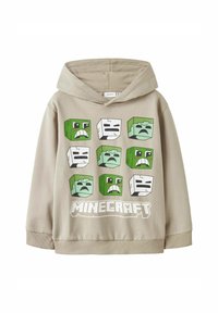 Sudadera con capucha beige que presenta estampados de personajes de Minecraft en verde y blanco. El diseño gráfico destacado incluye expresiones faciales y el logotipo.