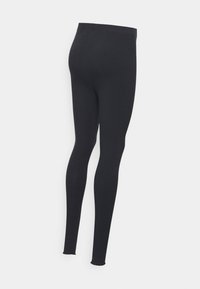 Leggings pretos canelados com um corte justo, cintura elástica e uma textura suave, desenhadas sem padrões ou hardware visível.