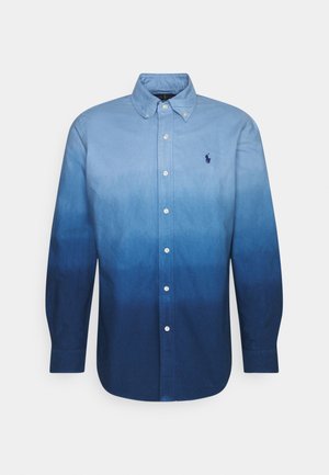 Męska koszula na długi rękaw zapinana na guziki, z gradientem koloru niebieskiego od jasnego u góry do ciemnego na dole, z kołnierzykiem zapinanym na guziki i logo na piersi.