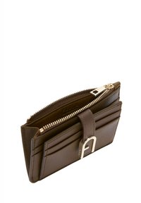 Portefeuille en cuir marron avec fermeture éclair, plusieurs emplacements pour cartes et un accent métallique. Présente une texture lisse et une forme rectangulaire compacte.