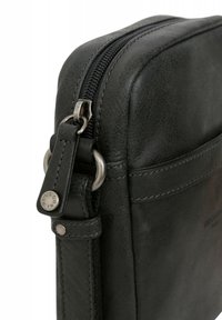 Borsa in pelle nera con una texture liscia, caratterizzata da una cerniera argentata e un accento metallico sul tirante della cerniera. Le cuciture sono visibili.