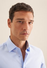  Lichtblauwe overhemdbloes met een contrasterende, gestreepte kraag. Glad textuur en slim fit. Korte mouwen, minimalistisch ontwerp.
