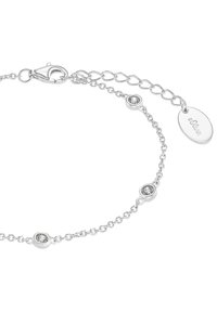 Bracciale a catena in argento con accenti di pietre trasparenti circolari, un gancio a granchio e una catena regolabile con un piccolo tag ovale.