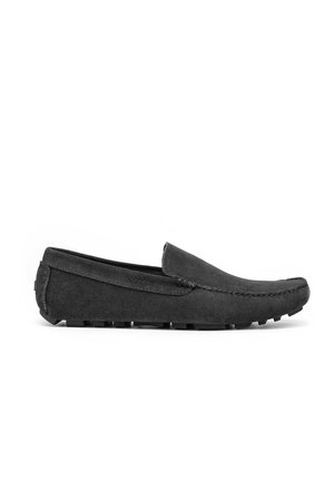 Mocassin pour homme en daim noir avec semelle en caoutchouc à picots et couture style mocassin, présenté en profil latéral.
