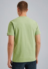 Světle zelené bavlněné tričko s krátkým rukávem a kulatým výstřihem. Hladká textura, minimalistic design a žádné viditelné loga ani vzory.