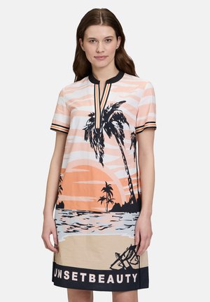 Kleid mit kurzen Ärmeln, das ein pfirsichfarbiges und weißes Streifenmuster, Palmbaum-Grafiken, einen schwarzen Kragen und den Text "SUNSETBEAUTY" am Saum aufweist.
