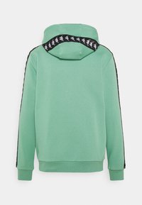 Sweatshirt à capuche vert clair avec des bandes latérales noires arborant un motif de logo répétitif. Tissu doux avec des poignets et un ourlet côtelés.