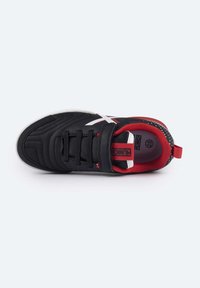Zapatilla deportiva negra con parte superior sintética texturizada, acentos rojos, logo blanco y sistema de cordones negro; interior acolchado para mayor comodidad.