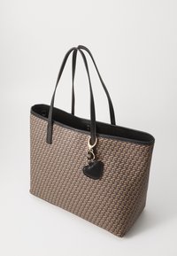 Brown woven tote bag with black leather accents, featuring long handles and a gold hardware charm shaped like a heart.