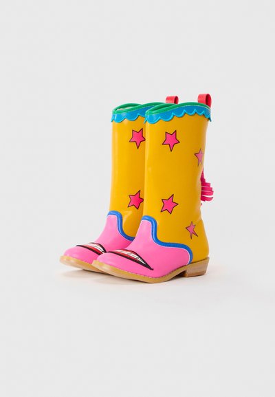 Yellow rain boots with pink accents, blue trim, and star patterns. Features a scalloped edge and pink soles with artistic detailing.