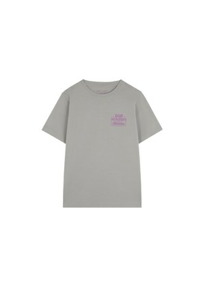 Camiseta gris claro fabricada en algodón, con cuello redondo, mangas cortas y un gráfico morado contrastante en el lado izquierdo del pecho.