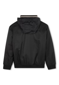 Veste en nylon noire avec capuche, poignets et ourlet élastiques, et fermeture à glissière à l'avant. Texture lisse et design simple sans motifs supplémentaires.