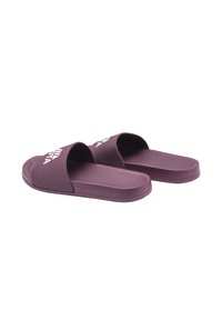 Sandales en caoutchouc violettes avec orteil ouvert et large sangle portant un logo de marque embossé. Semelle intérieure texturée pour une meilleure adhérence. Design minimaliste.