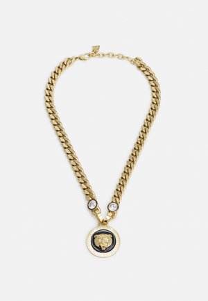 Gouden ketting met een ronde hanger met een leeuwmotief, verfraaid met twee heldere stenen en een zwarte ronde rand.