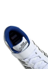 Basket blanche avec des motifs en toile noire, doublure en textile bleu et lacets blancs. Présente la marque "Marvel Spider-Man" sur la languette.