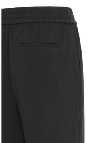 Pantaloni jogging neri con vita elastica, dotati di una tasca sul retro e tessuto liscio e strutturato. Il design semplice sottolinea la funzionalità.