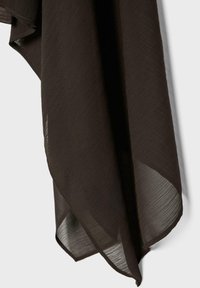 Tissu léger brun foncé avec un motif texturé subtil, suspendu avec un bord légèrement translucide sur un fond clair.