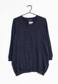 T-shirt à manches longues bleu marine en tissu doux, avec un col rond, une coupe décontractée et un ourlet légèrement arrondi. Suspendu à un crochet noir.