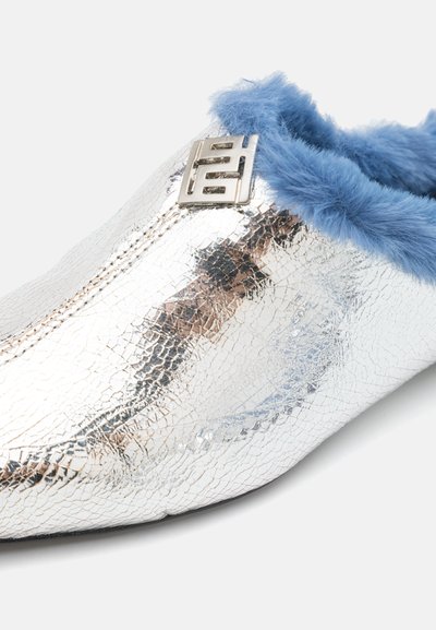 Sølv metallisk slip-on sko med teksturert finish, blå kunstpelsbesetning og sølv aksentdetalj på overdelen. Flat såle design.