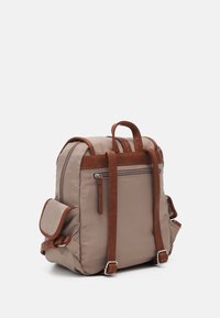 Beige-reppu, jossa ruskeat nahkaiset yksityiskohdat, suorakulmainen muoto, pehmustetut sivut, yläkahvat ja edessä vetoketjulla suljettava tasku nahkaisella vetimellä.