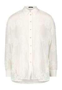 Blouse blanche en tissu transparent ornée de motifs floraux brodés. Col classique et fermeture à boutons avec des boutons semblables à des perles. Manches longues.