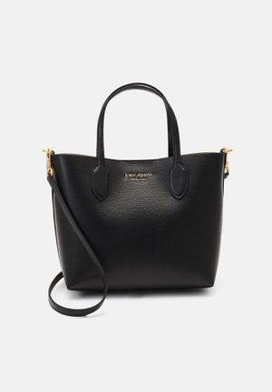 Sac à main en cuir noir Kate Spade avec poignées courtes, longue bandoulière réglable, ferrures dorées et logo au centre devant.