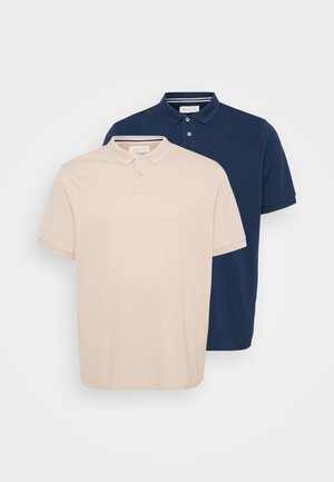 Due polo shirt: uno beige e uno blu navy. Entrambi presentano un colletto, maniche corte e pattini con bottoni. Tessuto in cotone morbido.