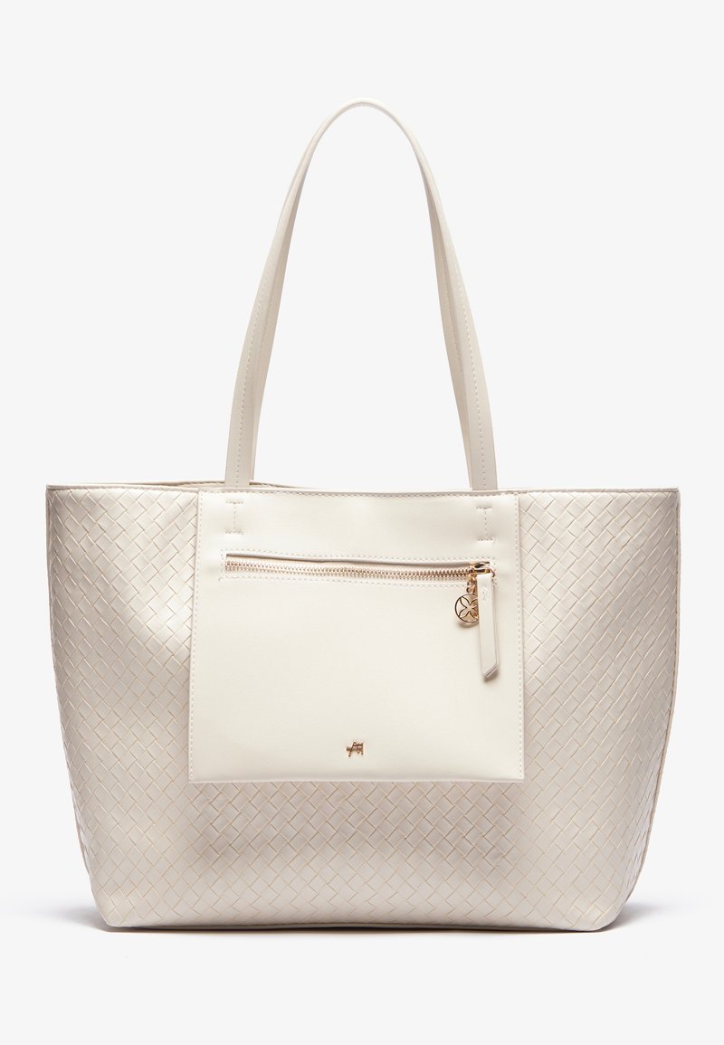 Sac fourre-tout couleur crème avec texture tissée sur les côtés, poche avant lisse avec fermeture éclair dorée et breloque, et deux fines poignées.