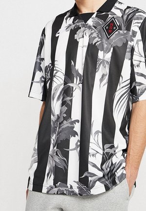 Das schwarz-weiß gestreifte Poloshirt verfügt über ein Blumenmuster, kurze Ärmel und einen Kragen. Logo in Rot auf der linken Brustseite.