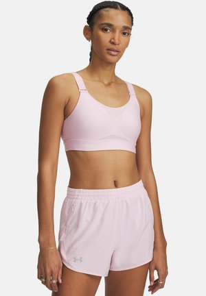 Lichtroze sportbeha met verstelbare schouderbanden en meshdetails, gecombineerd met bijpassende lichtgewicht shorts met een elastische tailleband en een zijrits.