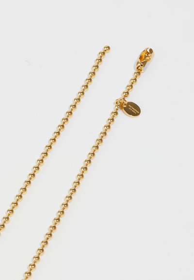 Collana con perline dorate caratterizzata da perle sferiche e chiusura a moschettone. Include un piccolo cartellino inciso con il nome del marchio.