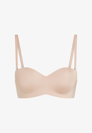 Nude-kleurige strapless beha met gladde, gevormde cups en dunne verstelbare schouderbandjes op een witte achtergrond.