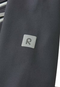 Tessuto nero con una superficie liscia presenta un logo sottile in argento, centrato sul materiale, con un design moderno e minimalista.