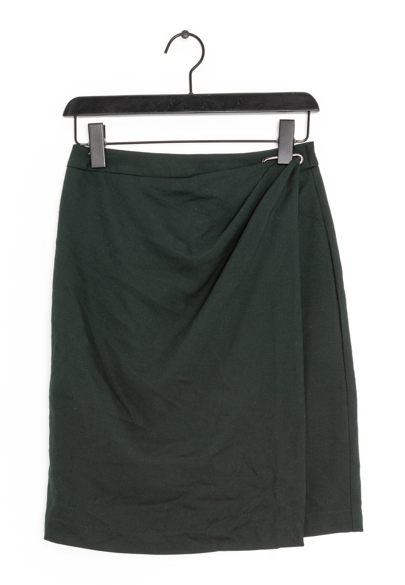 Tmavě zelená zavinovací sukně vystavená na černém ramínku. Materiál vypadá měkký s jemnou strukturou; má zkroucený detail na jedné straně.